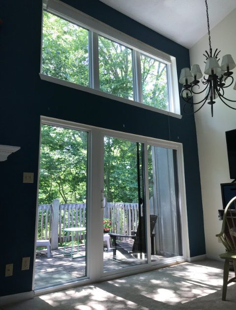 A living room with sliding glass doors and a chandelier