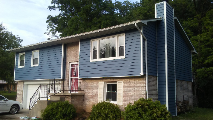 A blue house with a white car parked in front of it