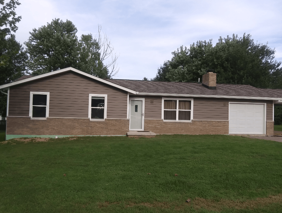 A large brown house with a white garage door