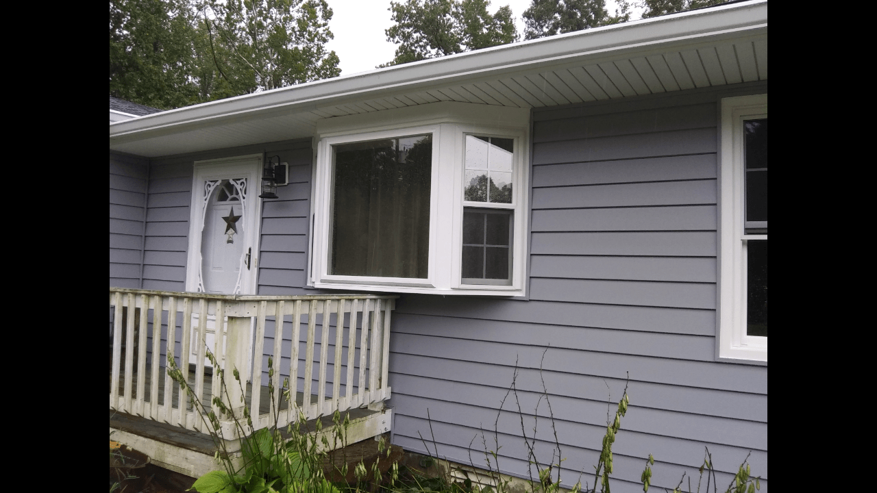 A gray house with a white window and a white porch.
