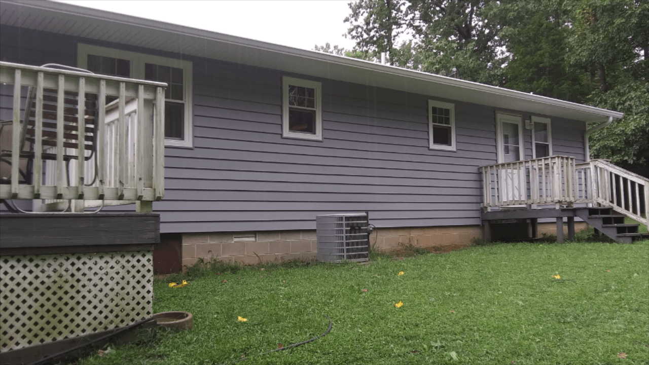 A purple house with a white deck and stairs