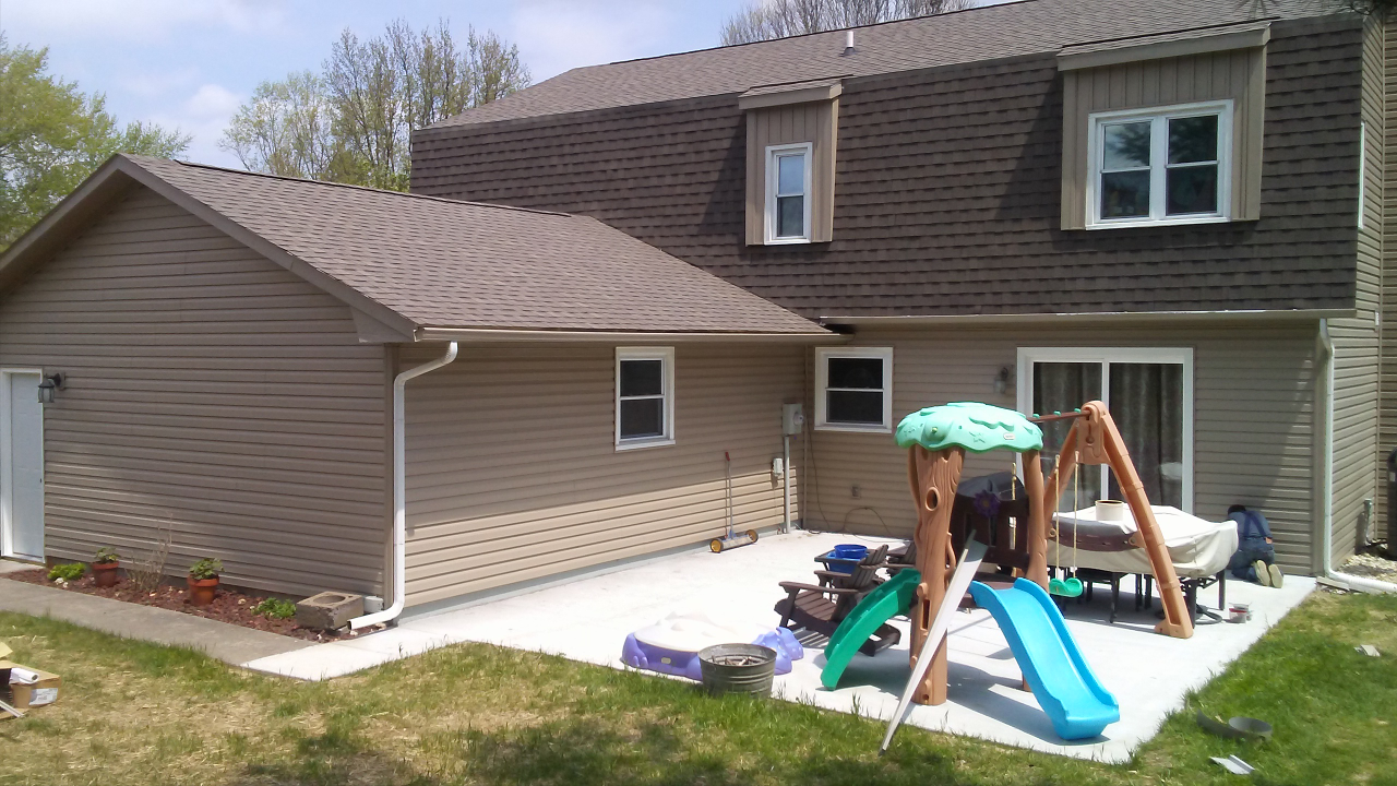The backyard of a house with a playground and a slide.