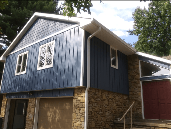 A house with blue siding and a red door