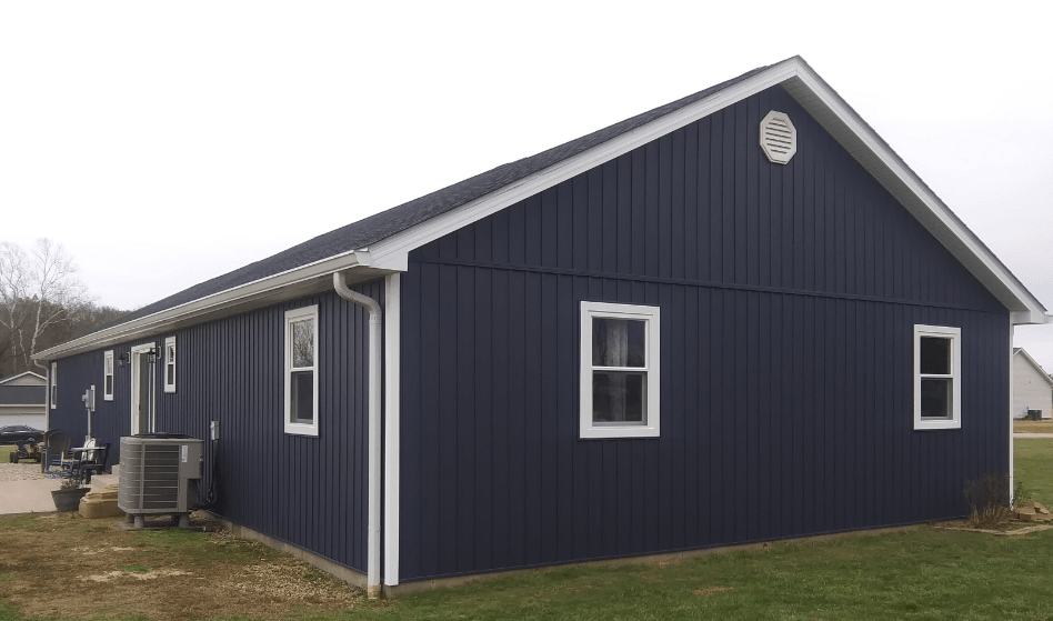 A blue house with white windows and a white roof