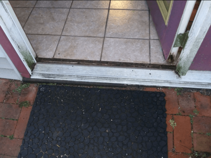 A door with a black mat in front of it