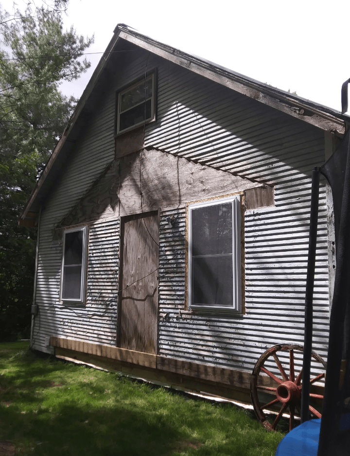 A house with a wagon wheel in front of it