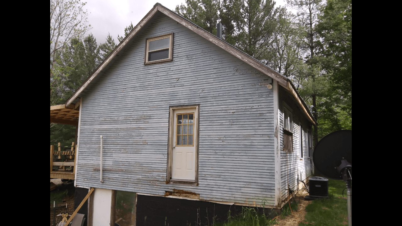 A small white house with a roof and a door
