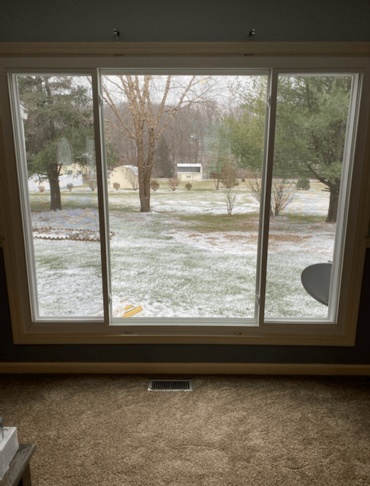 A living room with a sliding glass door looking out to a snowy yard.