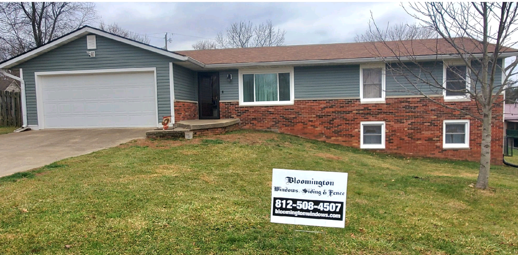 A house with a for sale sign in front of it.