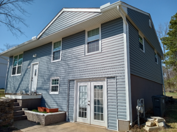 The back of a house with blue siding and white trim