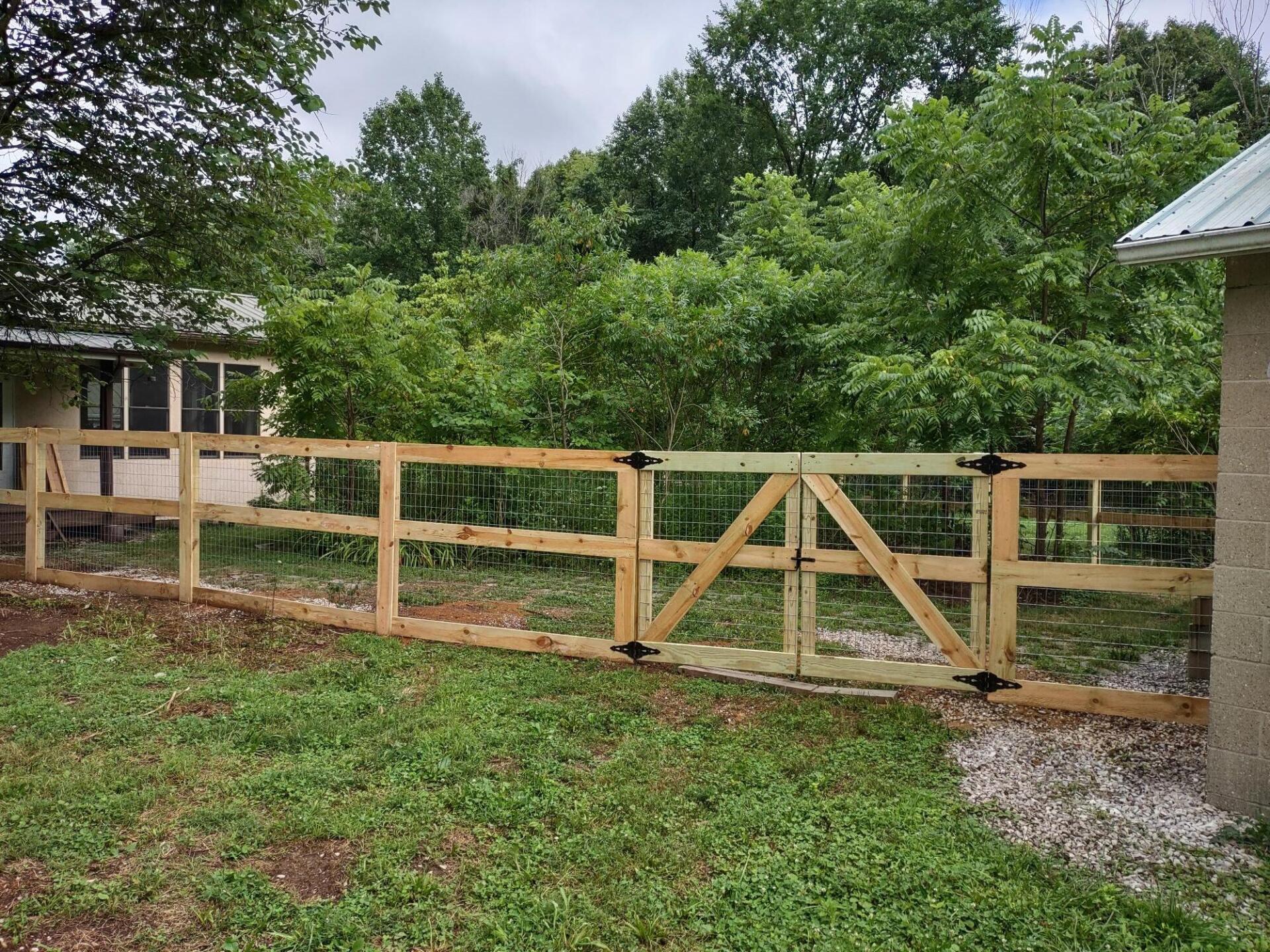 A wooden fence with a gate in the backyard of a house.