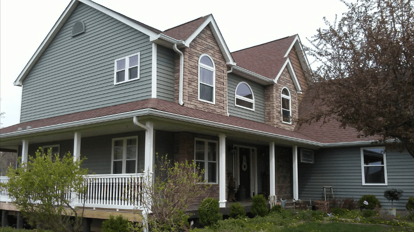 A large house with a large porch and lots of windows