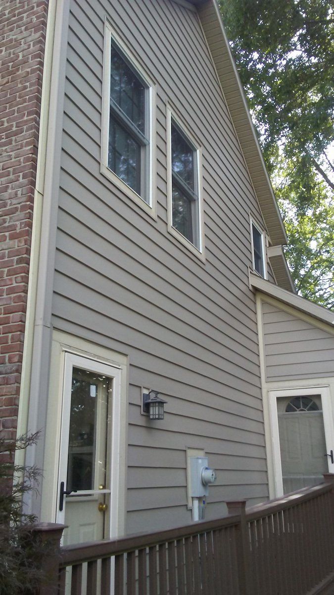 A house with a lot of windows and a fence in front of it.