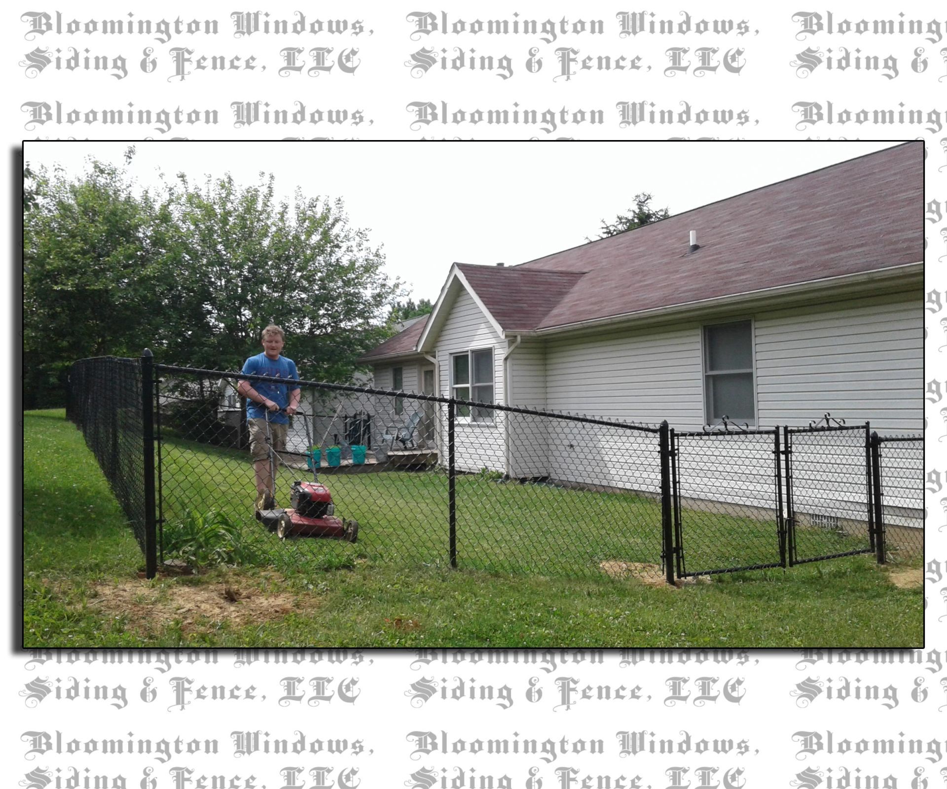 A man is standing in front of a chain link fence