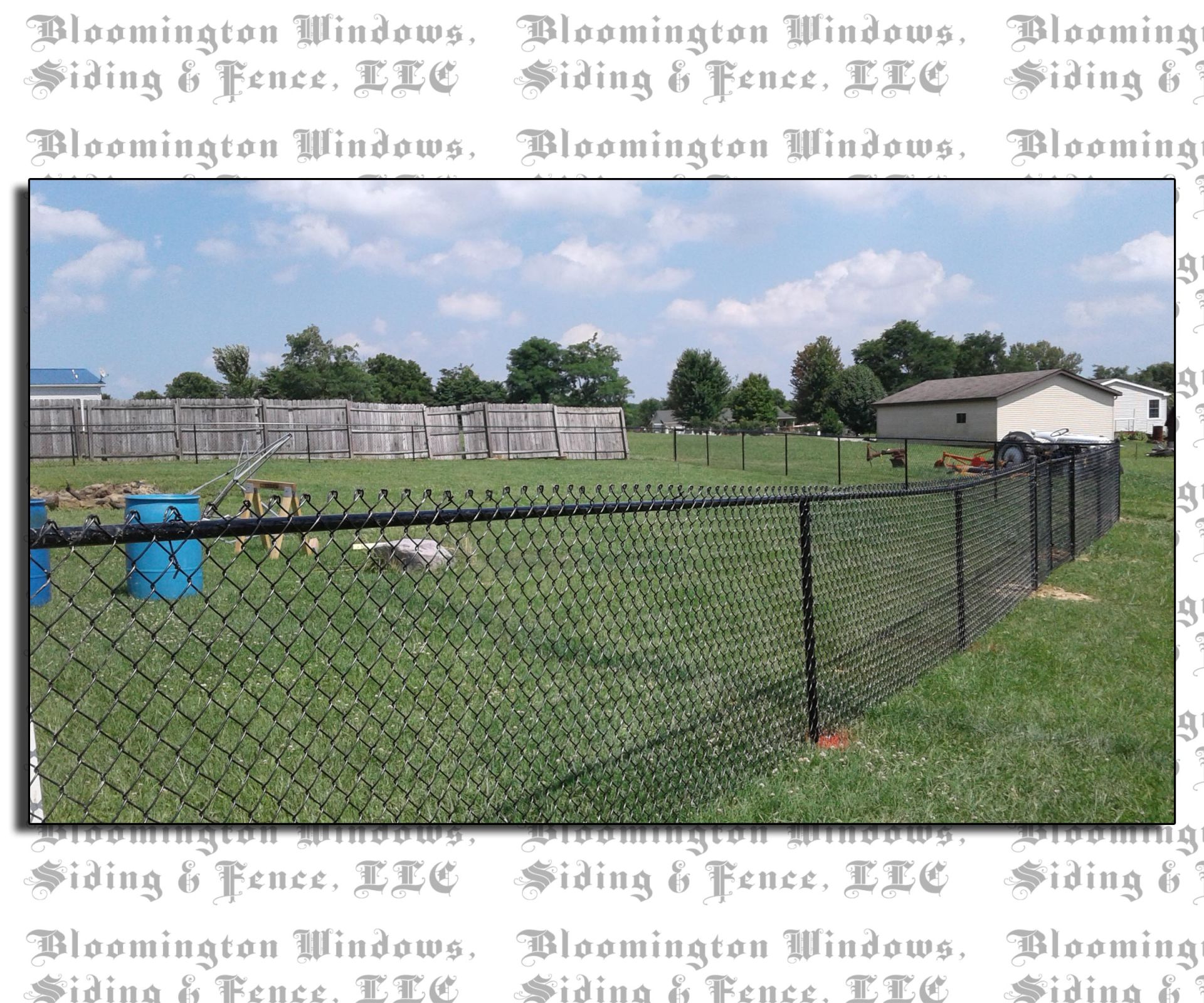 A chain link fence surrounds a lush green field