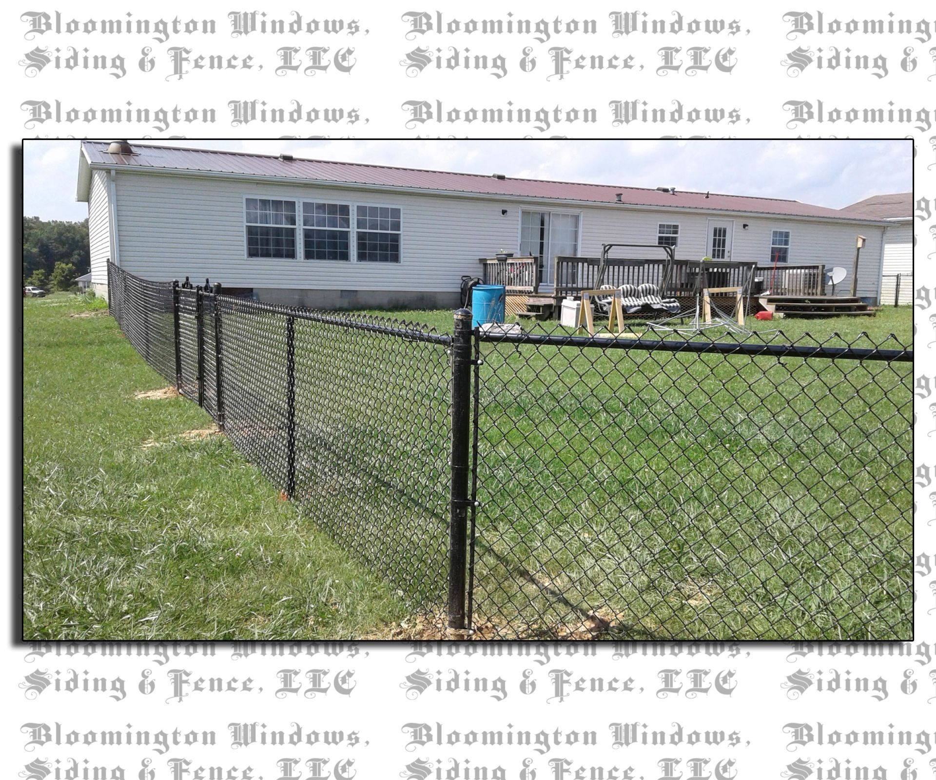 A chain link fence is in front of a mobile home