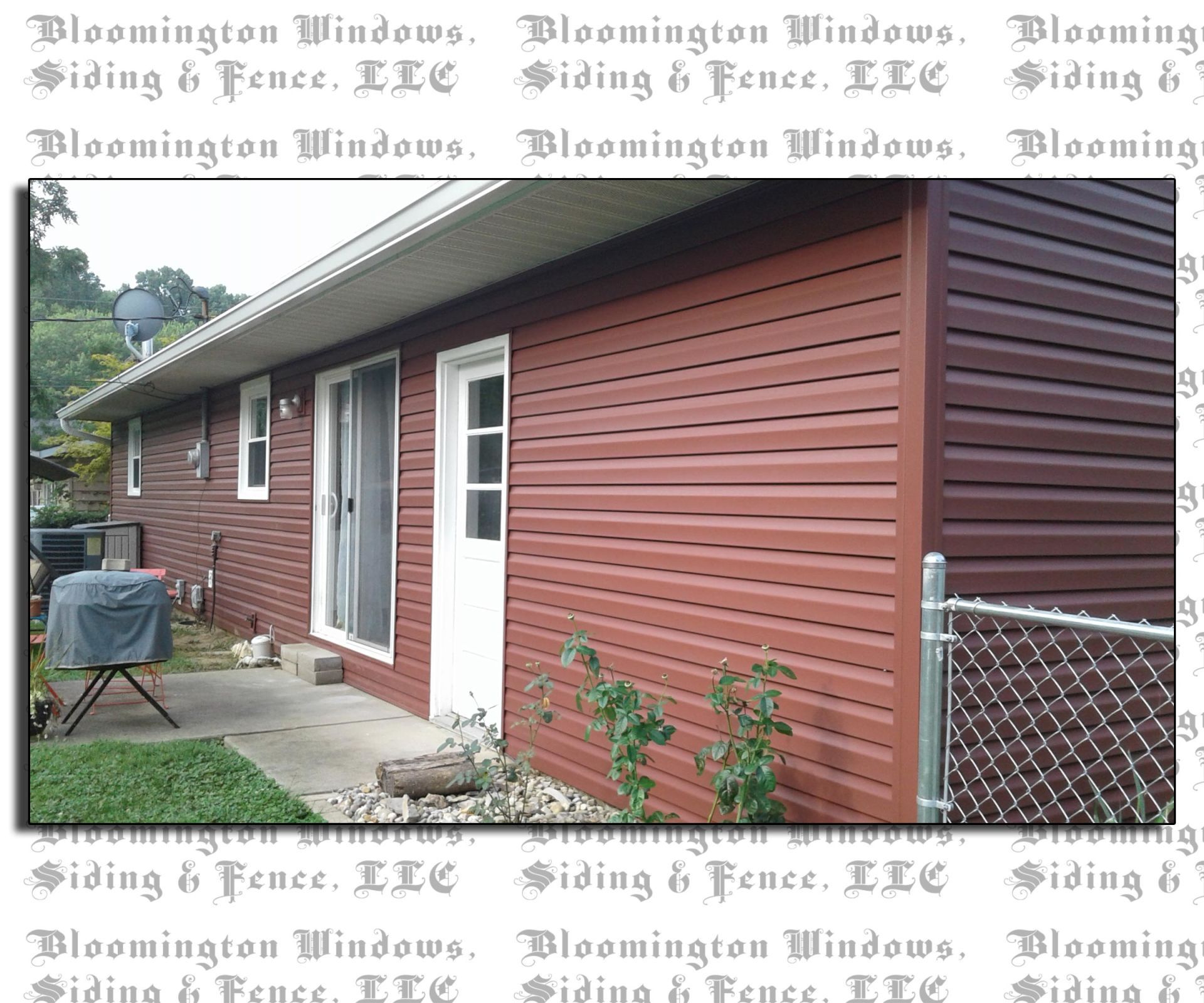 A picture of a house with red siding and a chain link fence