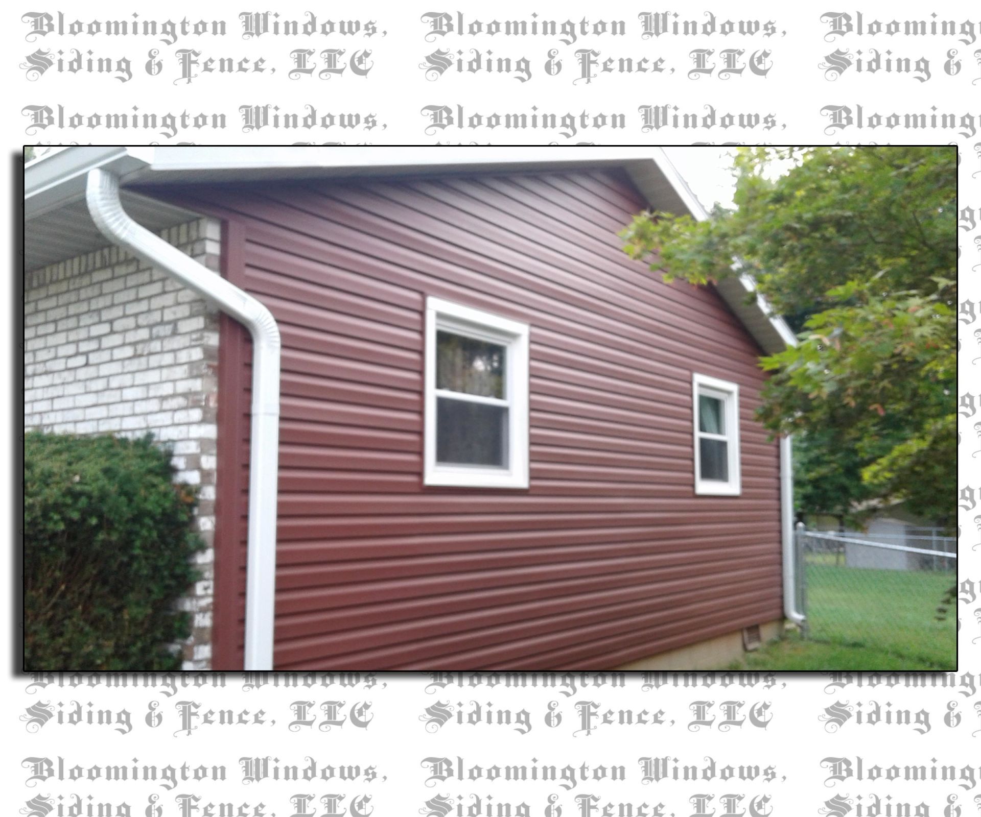 A picture of a house with red siding and white windows