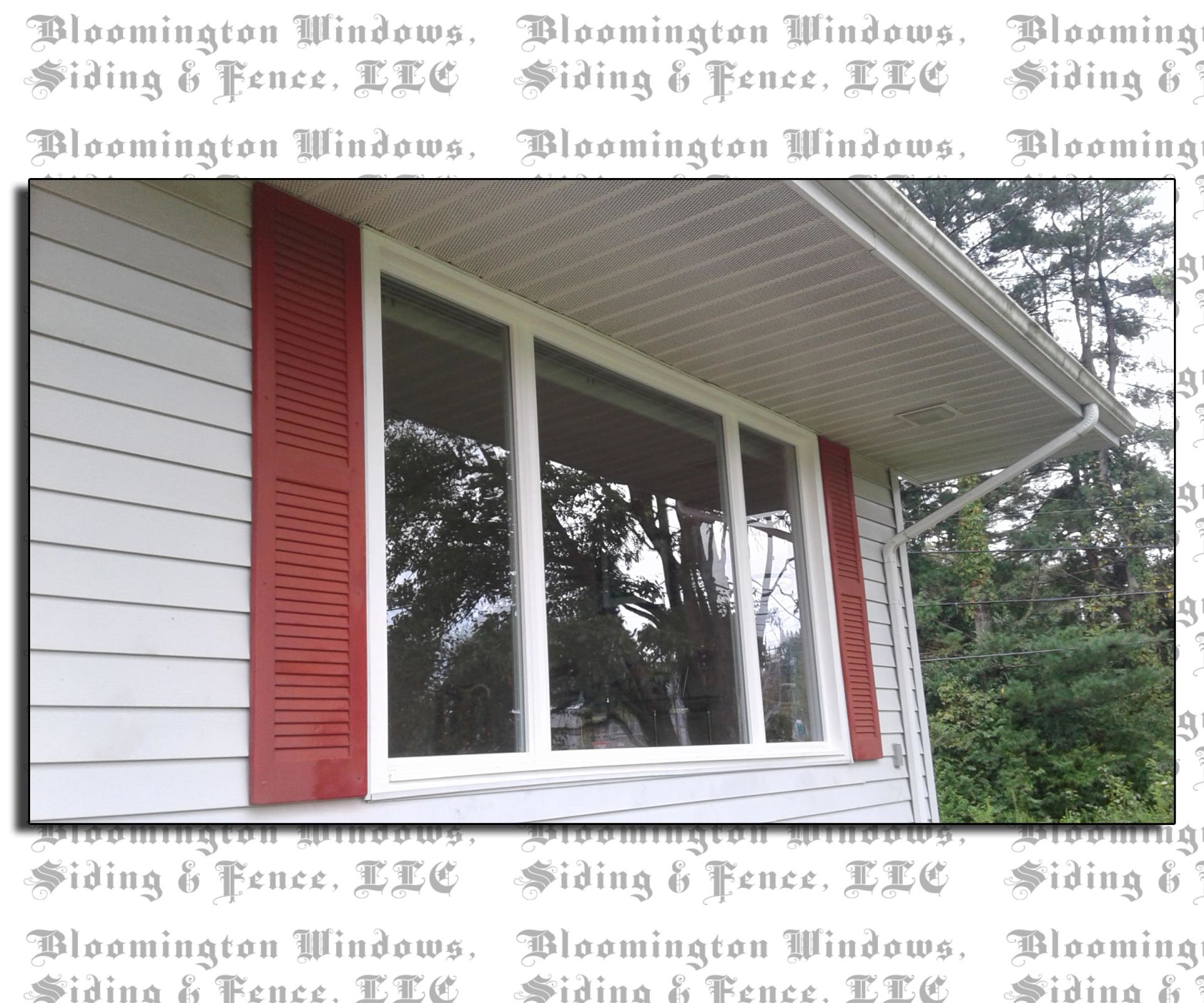 A white house with red shutters and a window from bloomington windows siding & fence llc