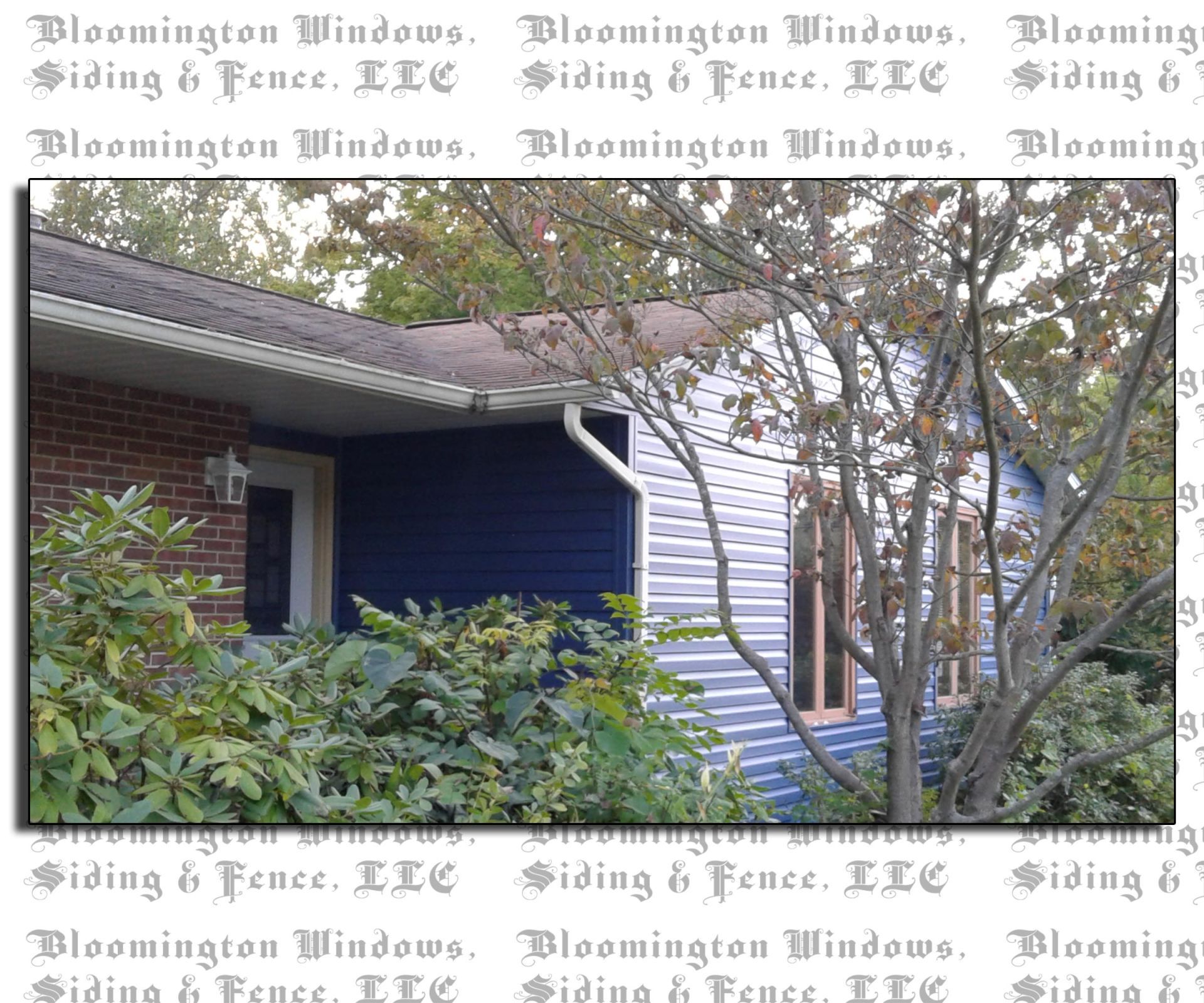 A picture of a house with blue siding and a tree in front of it