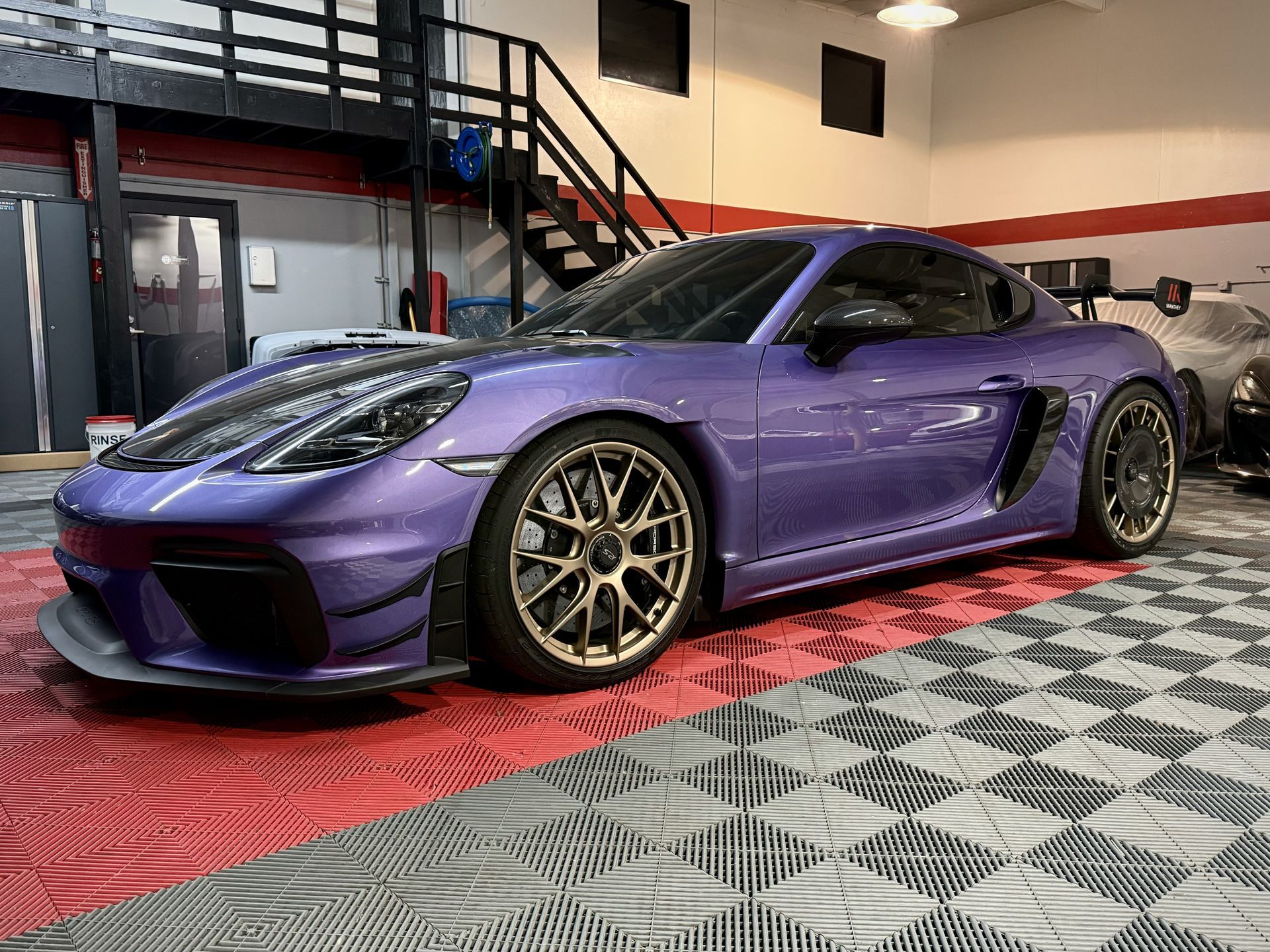 A man is inflating a tire on a white car.