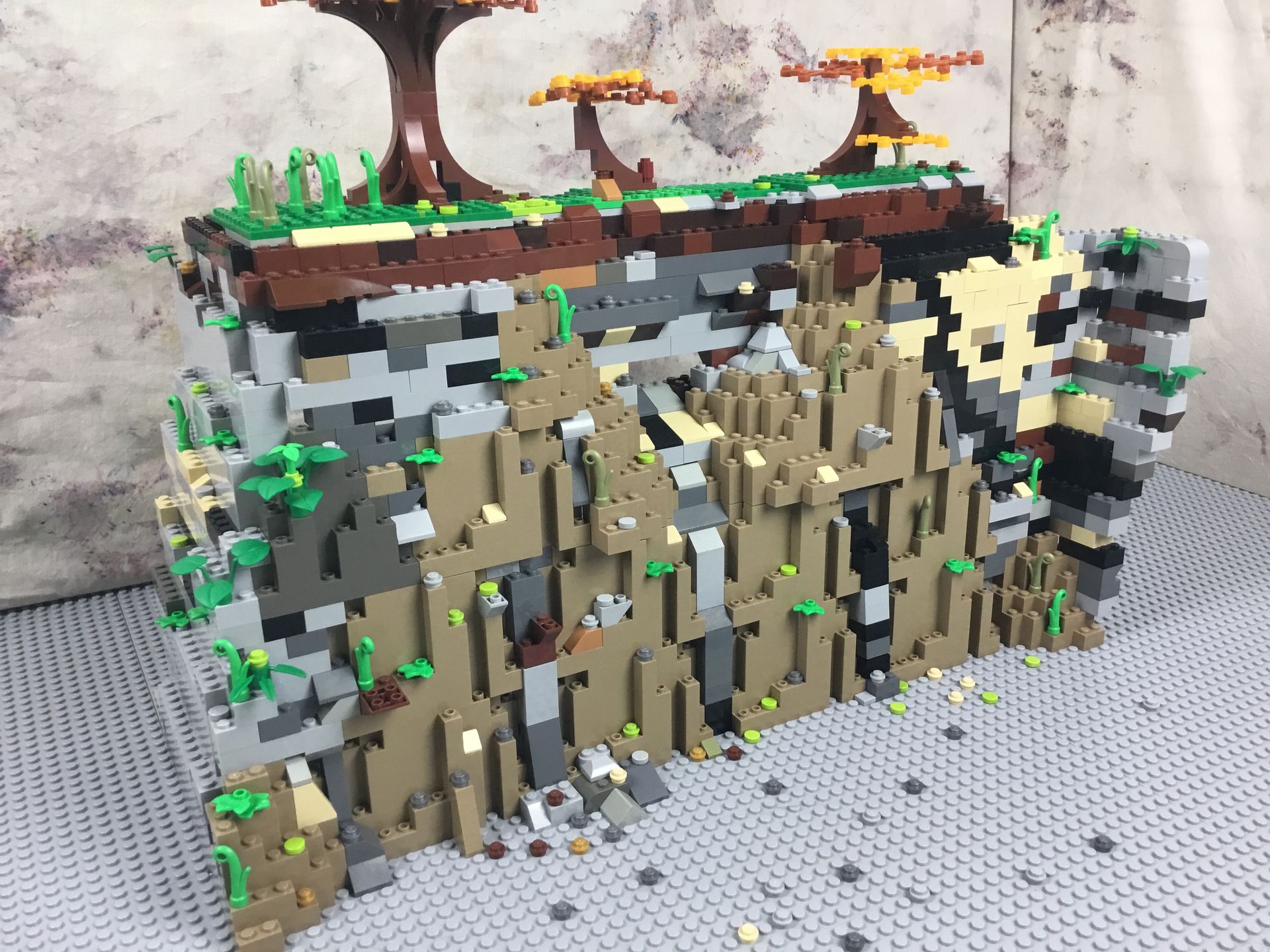 Een legomodel van een rotsachtige klif met bomen erop.