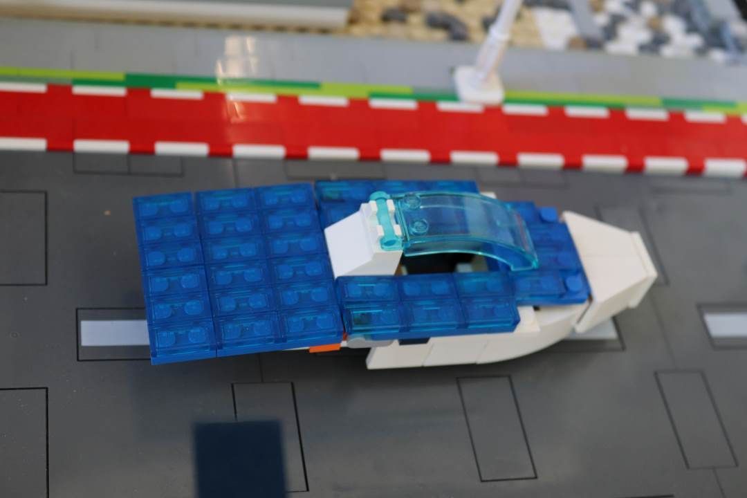 Een blauw-wit legovliegtuig staat op een landingsbaan.