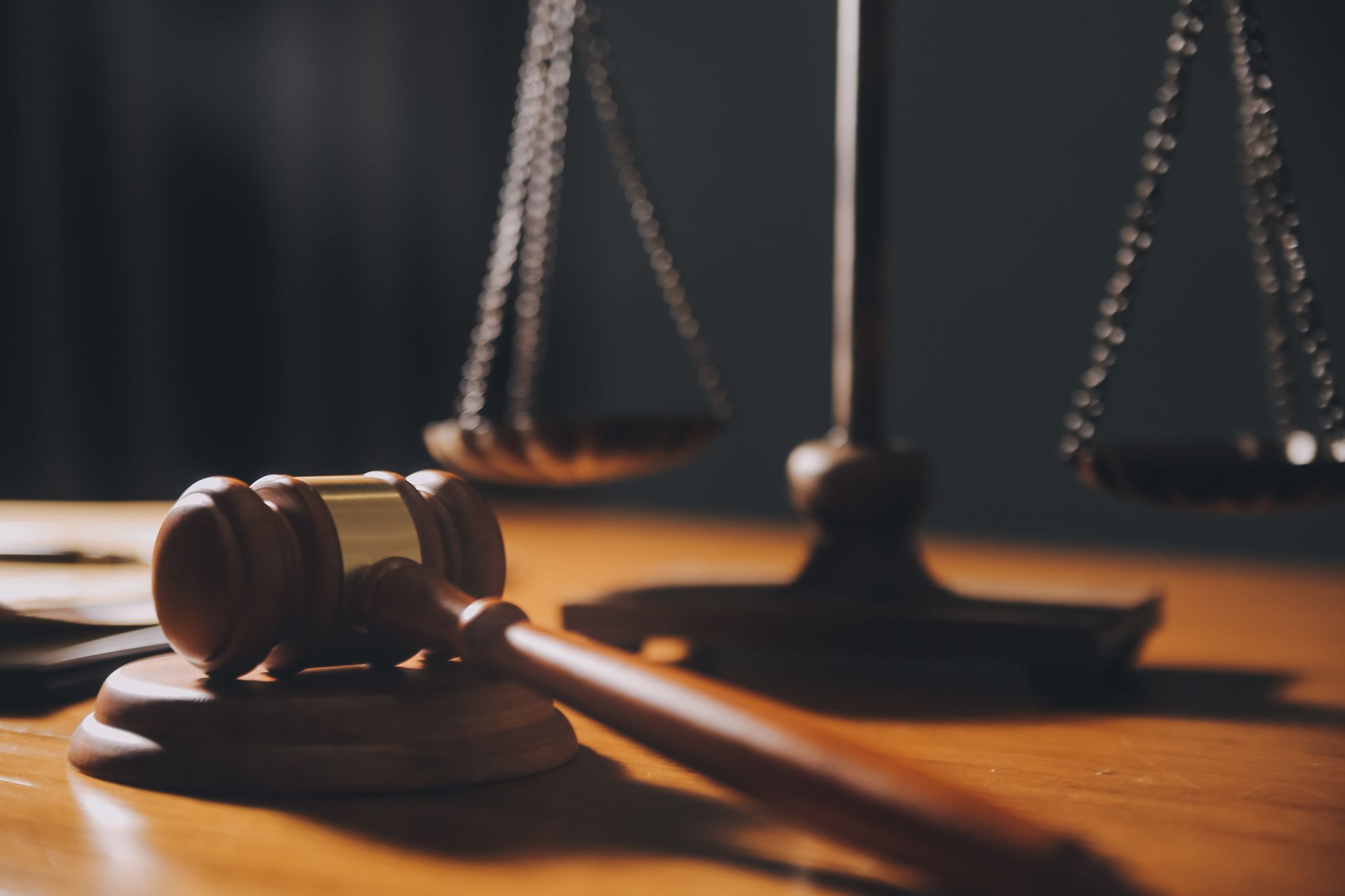 A judge 's gavel and scales of justice are on a wooden table.