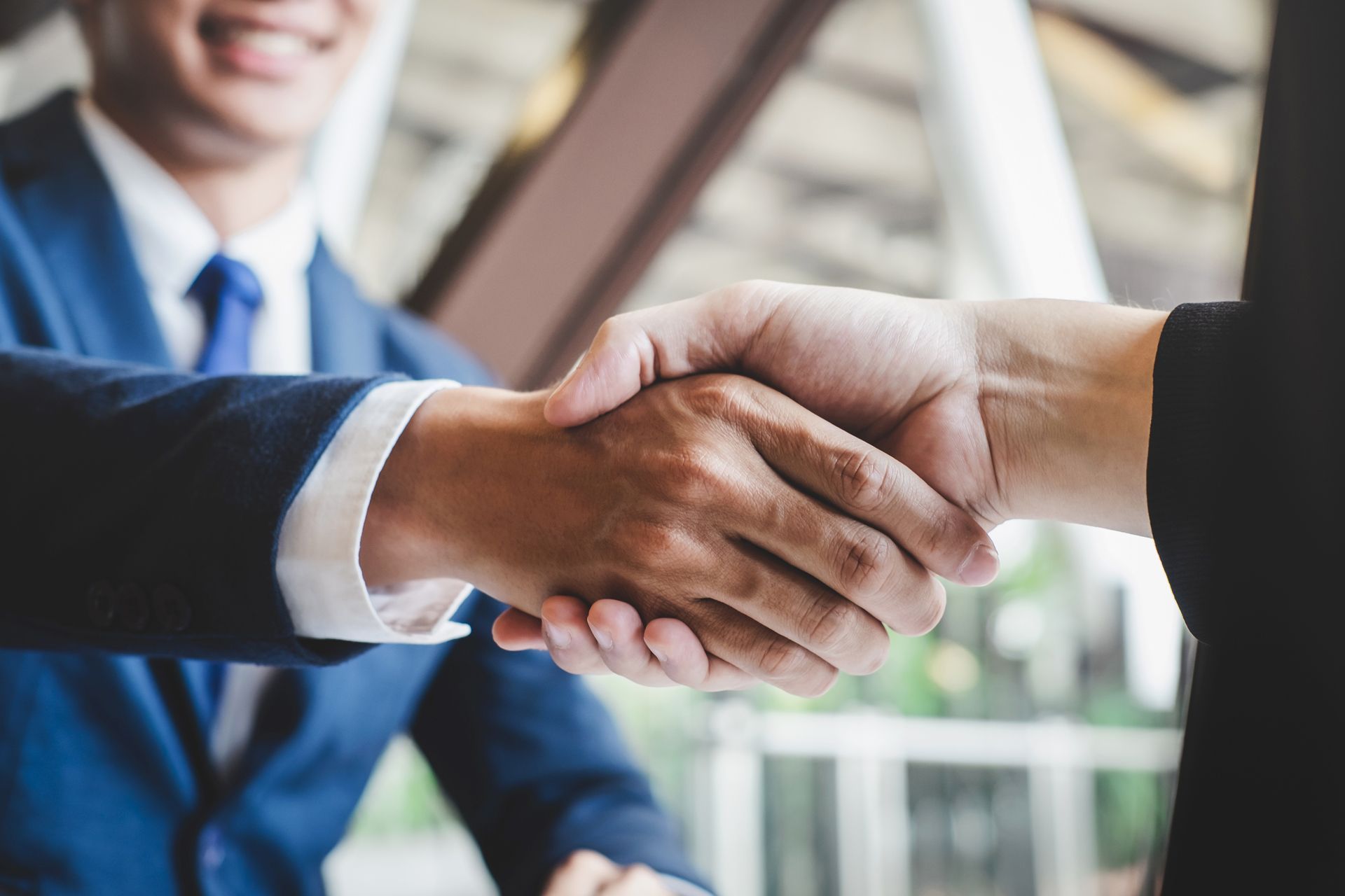 A man in a suit and tie is shaking hands with another man.