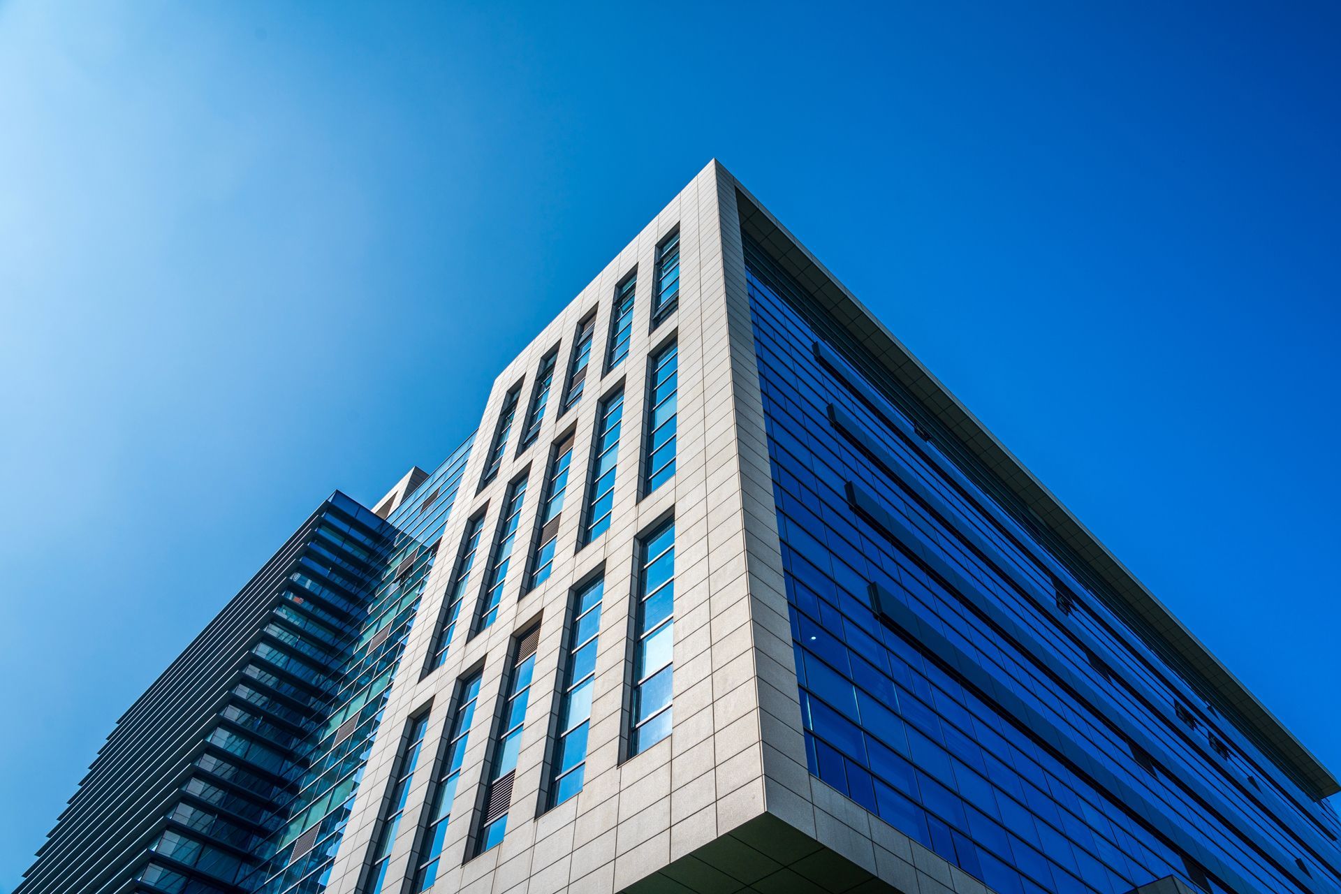 Looking up at a tall building with a blue sky in the background.