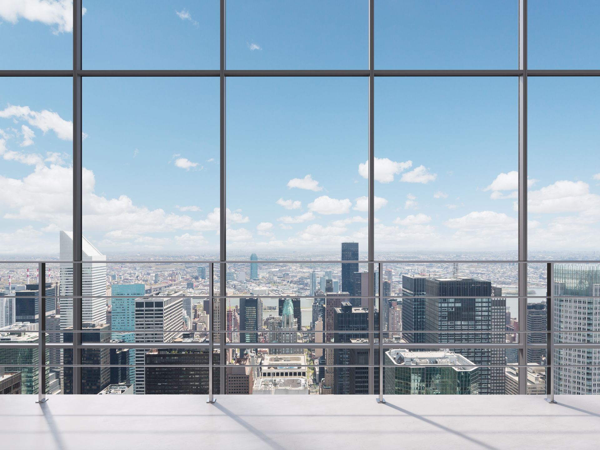 An empty room with a view of a city through a large window.