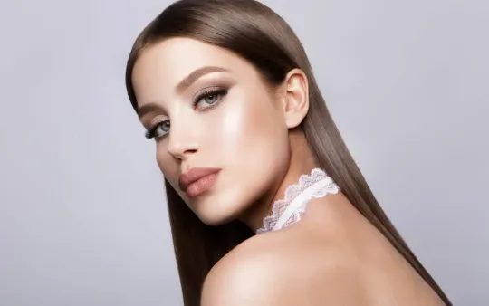 A Woman with Long Hair and A Choker on Her Neck Is Looking Over Her Shoulder.