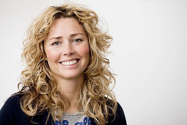 A Woman Is Touching Her Neck and Shoulder with Her Hand.