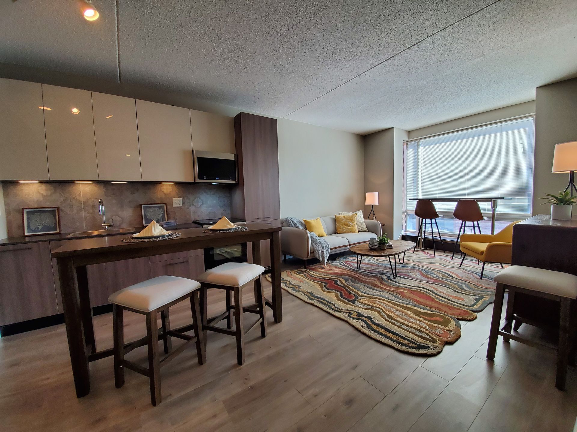 A living room with a couch , table and chairs