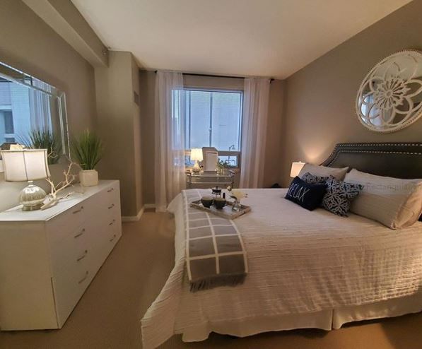 A bedroom with a large bed and a dresser