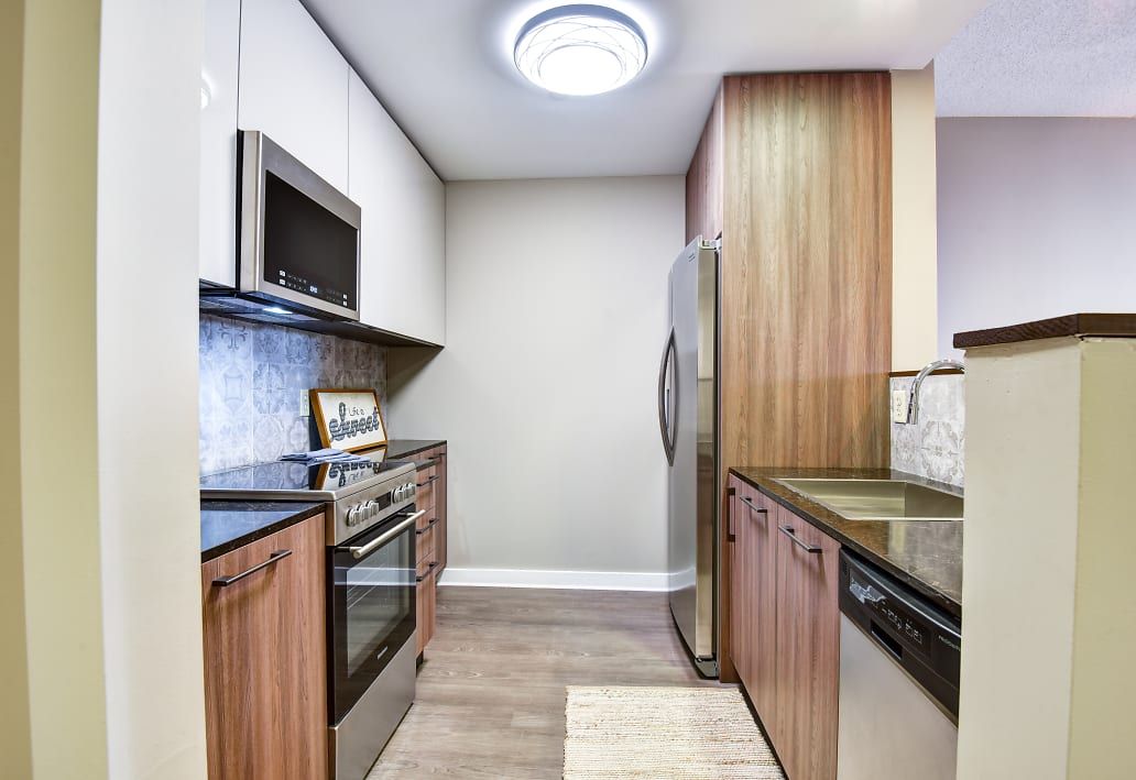 A kitchen with stainless steel appliances and wooden cabinets