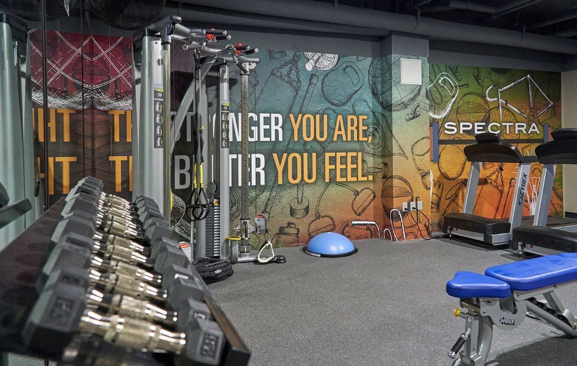 A gym with a mural on the wall that says `` wherever you are , be the way you feel ''.
