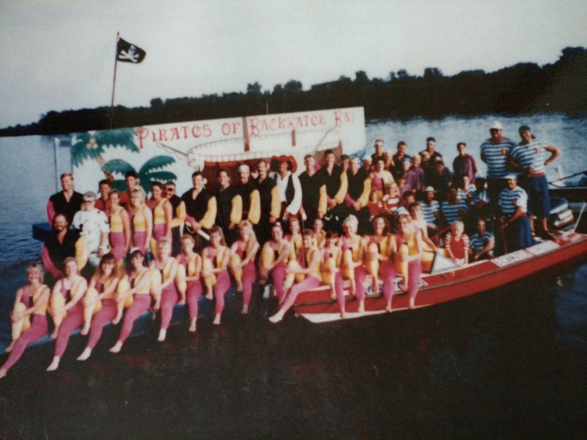 A group of people posing in front of a sign that says Pirates of the Caribbean