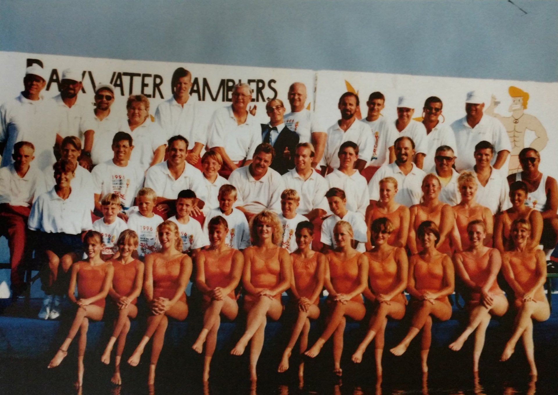 A large group of people are posing for a photo on a dock