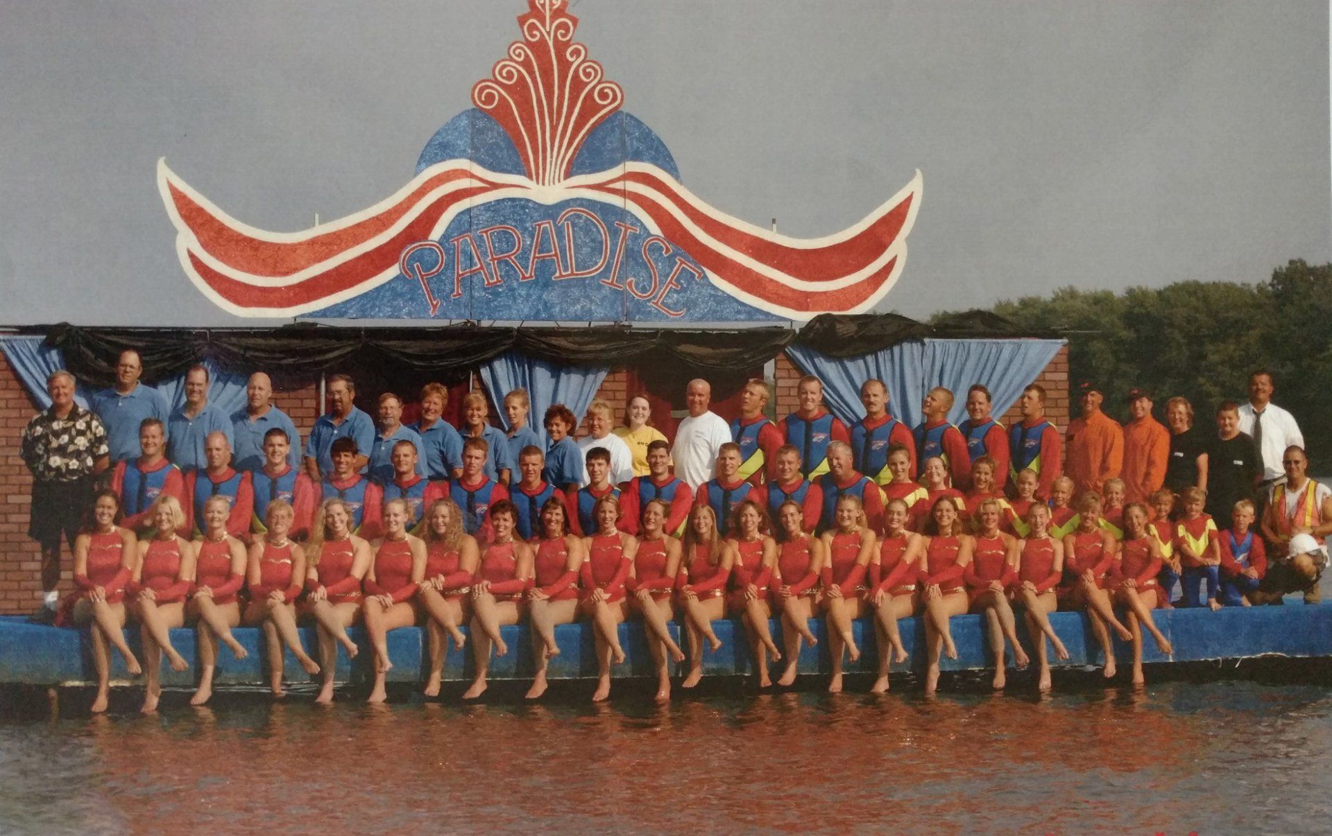 A large group of people are posing for a picture on a dock
