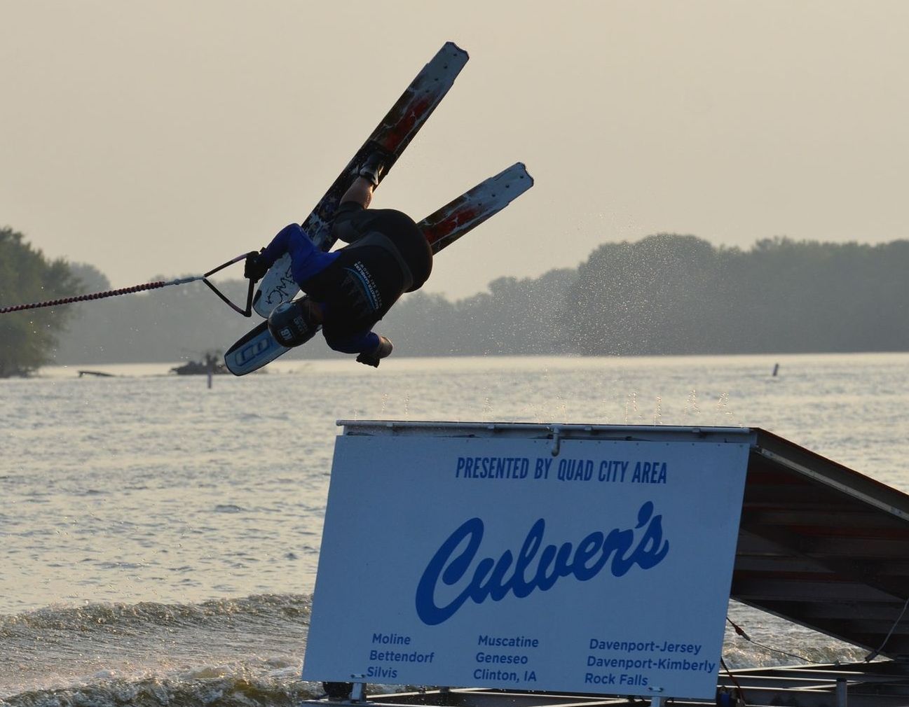 A person is doing a flip off a jump ramp with a Culver's sign