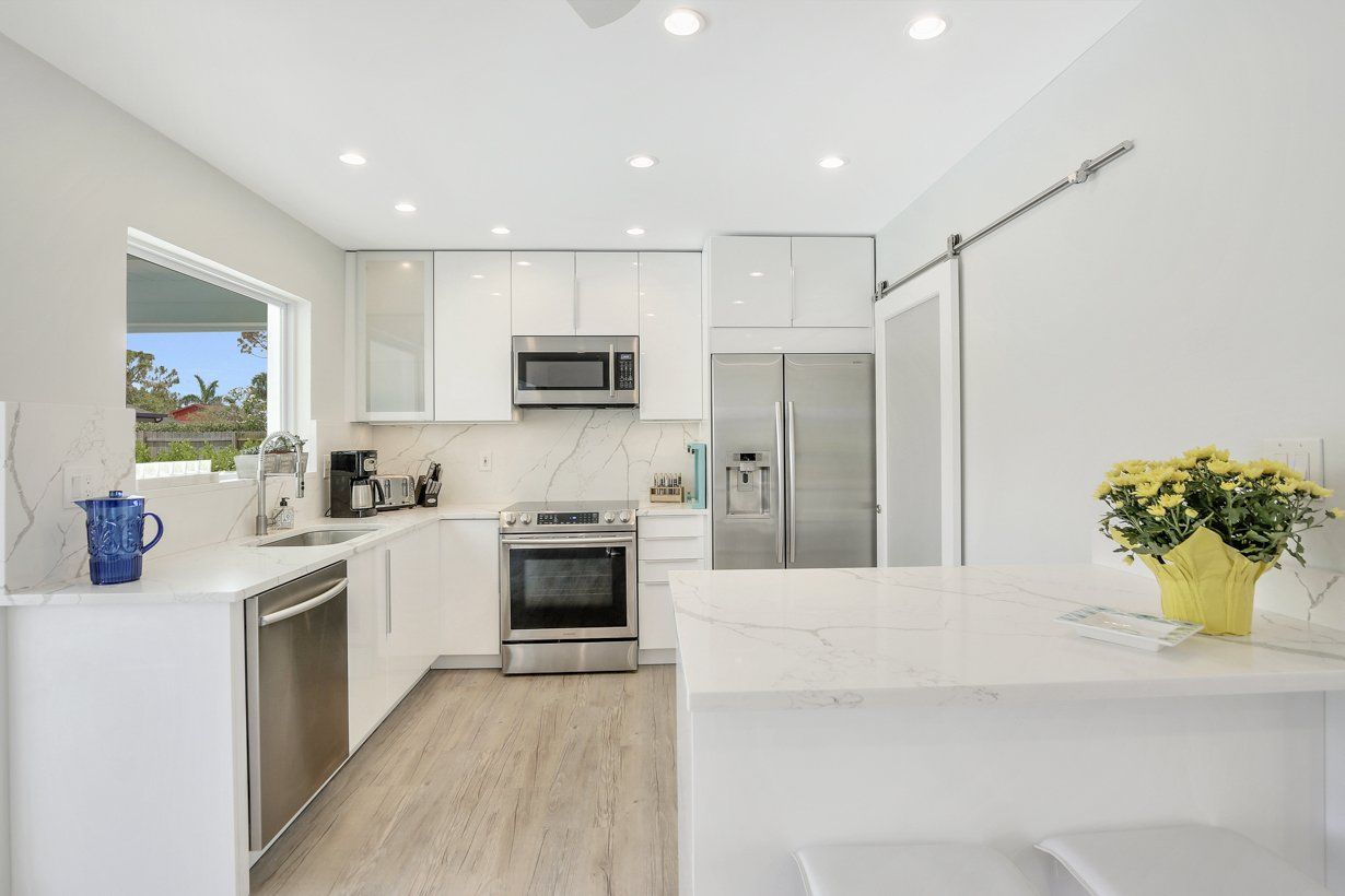 A kitchen with white cabinets and stainless steel appliances