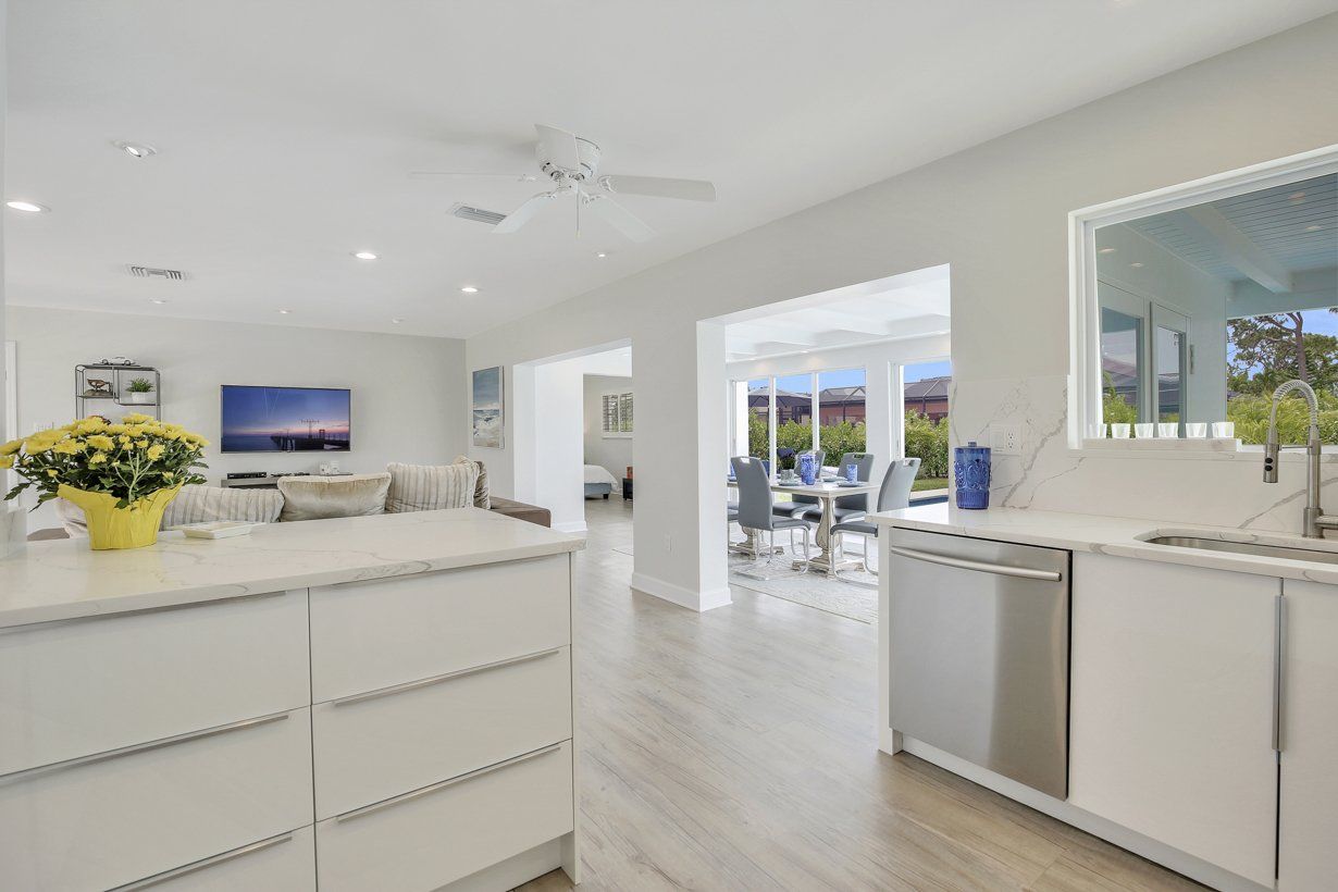 A kitchen with white cabinets and a stainless steel dishwasher.