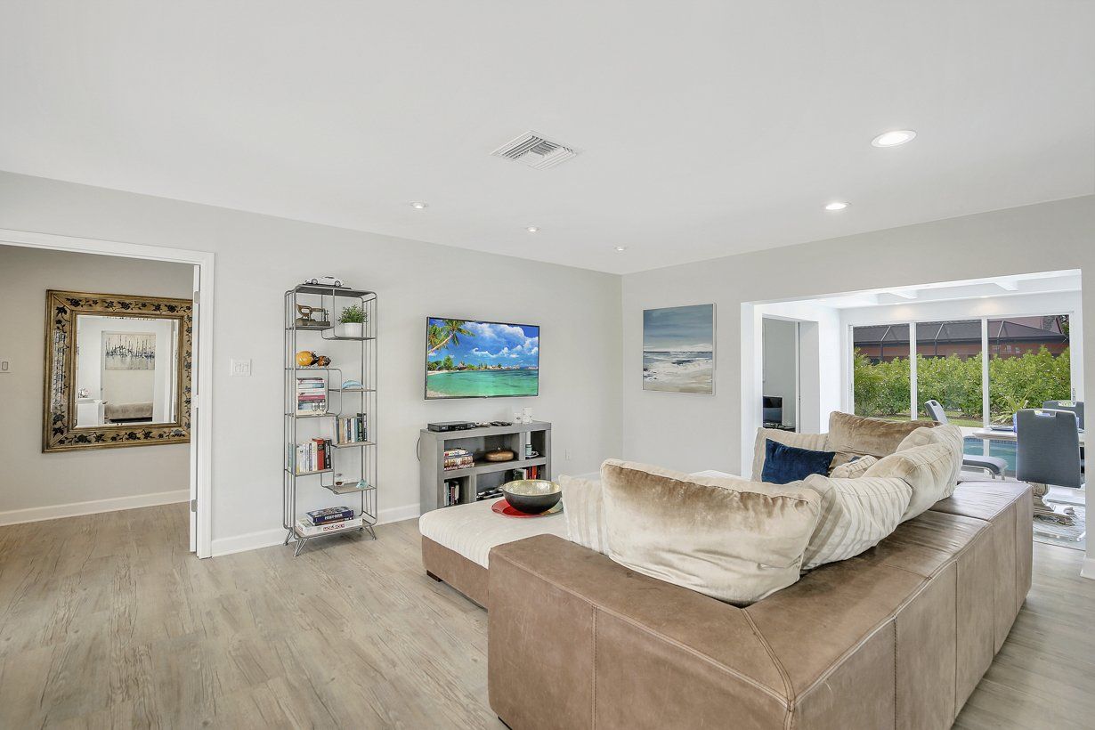 A living room with a couch and a television on the wall.