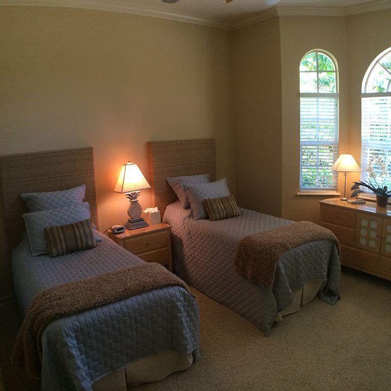 A bedroom with two twin beds and a window