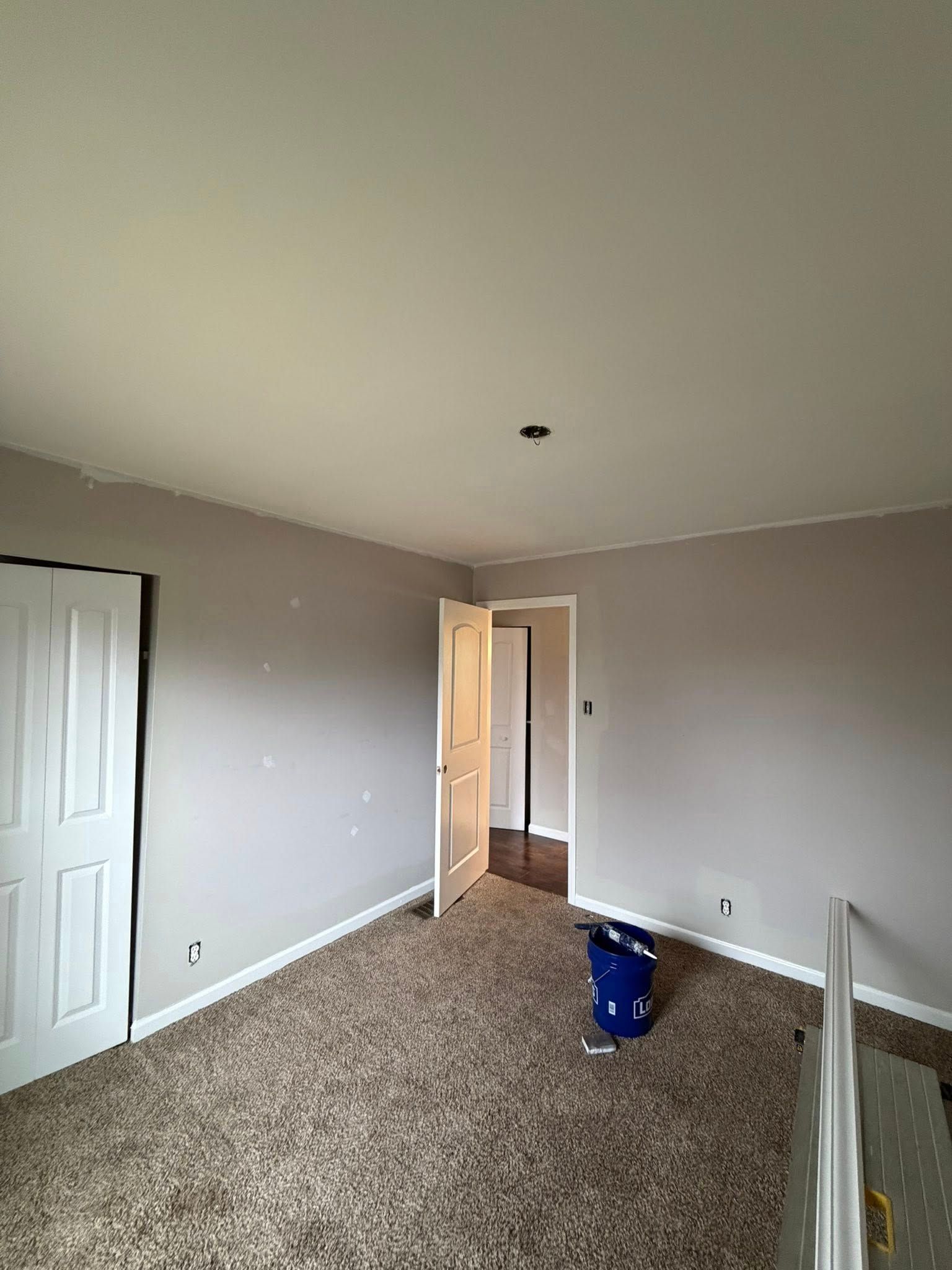 Room with brown carpet, gray walls, white trim, and a doorway.