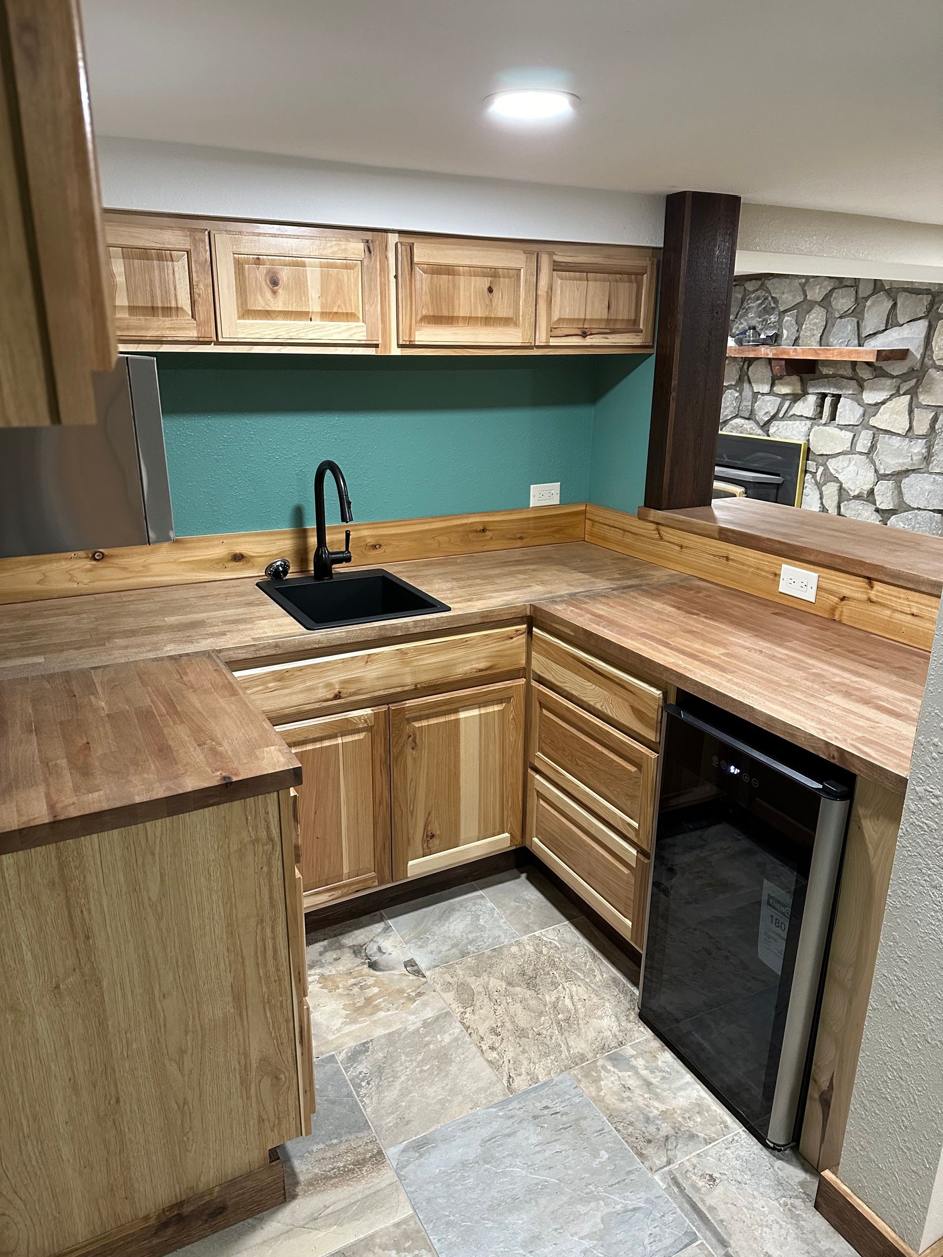 A kitchen with wooden cabinets , a sink , and a refrigerator.