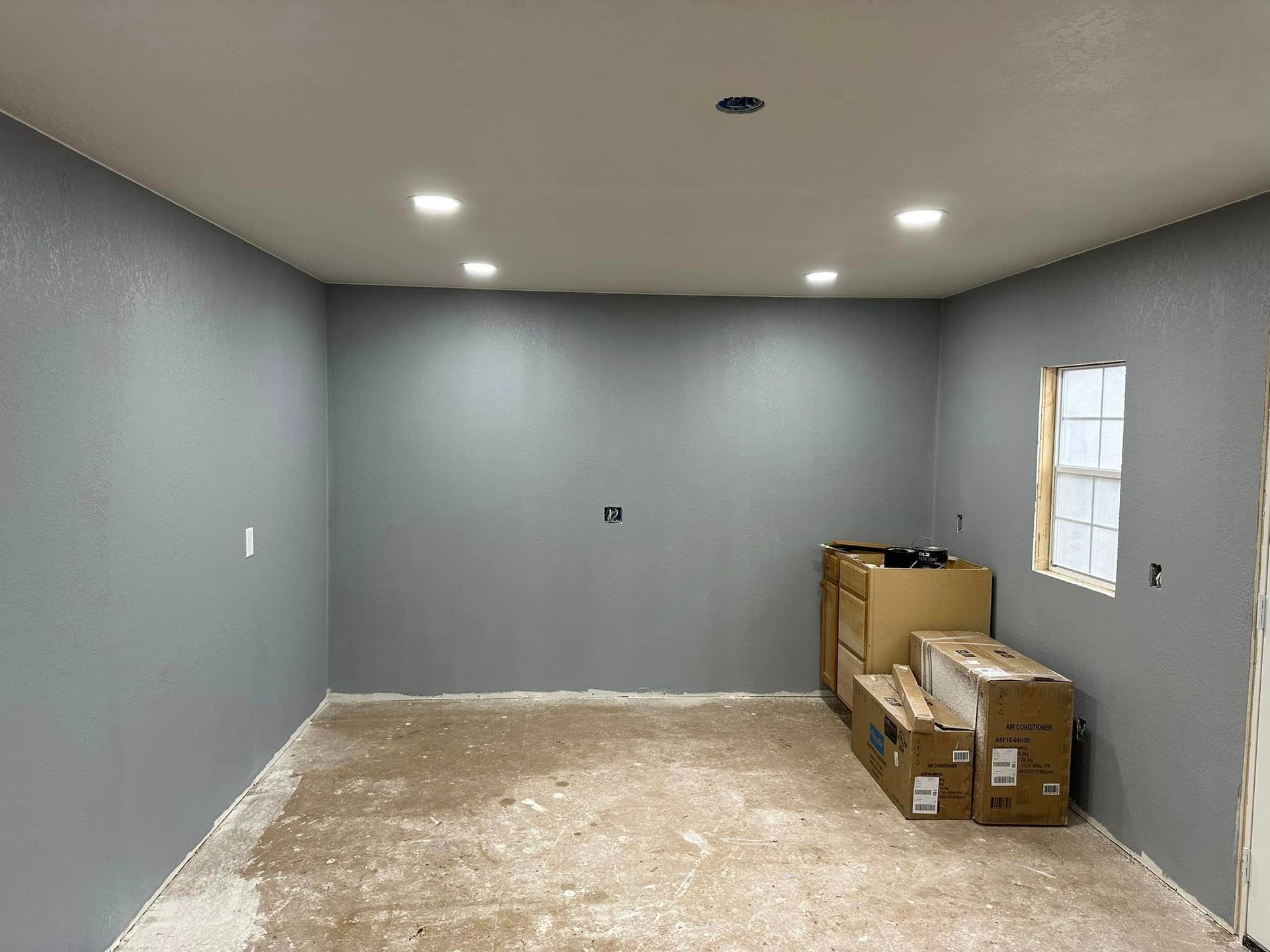 A room with a lot of boxes on the floor and a window.