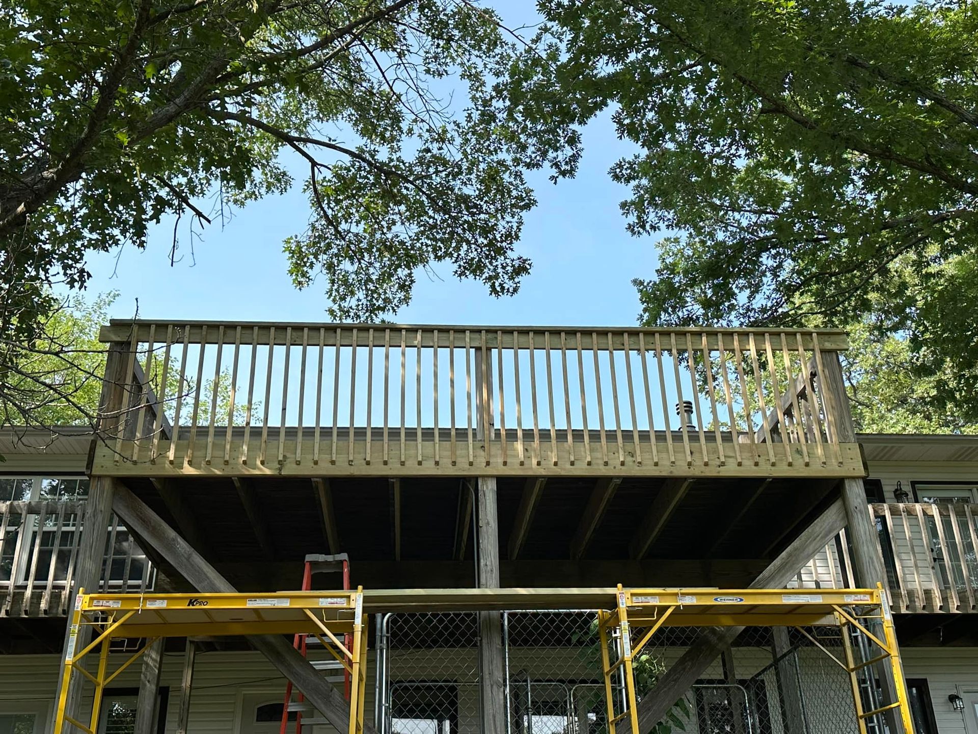 A wooden deck is being built on top of a house.