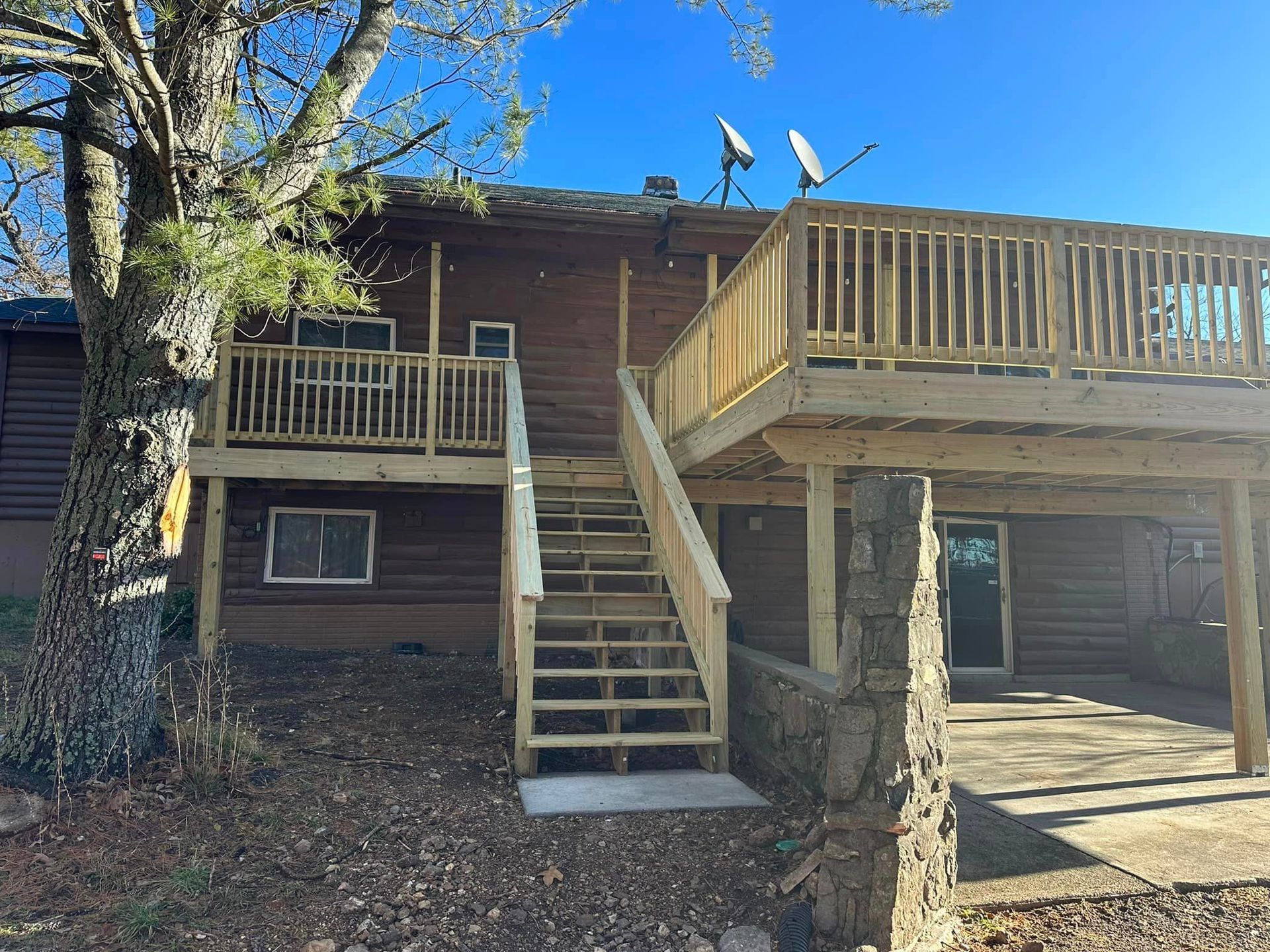 A house with a large deck and stairs leading up to it.